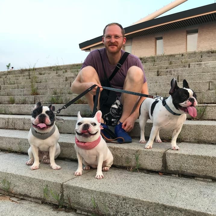 Edward Bacal at Komazawa Olympic park holding three french bulldogs on a leash